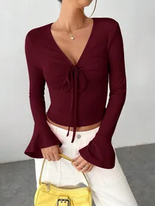 Detail of burgundy ribbed V-neck top with drawstring front and elegant bell sleeves