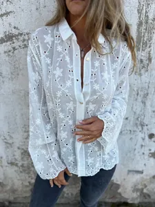 Nahaufnahme der weißen Baumwoll-Leinen-Bluse mit Blumenstickerei und Lochmuster-Details.