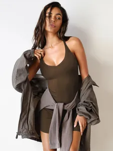 Detail of Y2K olive green halter bodycon mini dress with layered streetwear styling