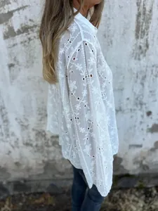 Detailansicht einer weißen Baumwoll-Leinen-Bluse mit floraler Stickerei und Lochmuster
