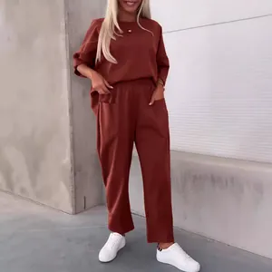 Elegantes ziegelrotes Set aus Rundhals-Langarmshirt und Hose mit Taschen für Damen in Einheitsfarbe