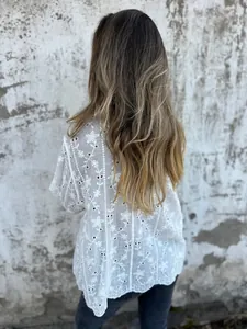 Rückansicht einer weißen Baumwoll-Leinen-Bluse mit zarter Blumenstickerei und Ösen.