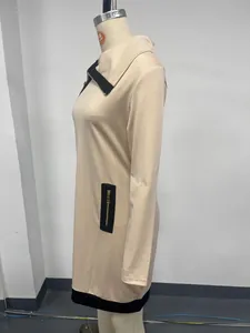 Side view detail of a beige long sleeve dress with black contrast zipper accents
