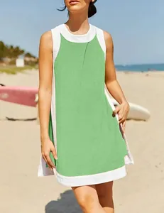 Close-up detail of a lime green and white sleeveless summer tunic worn on a sunny beach.