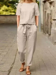 Elegant beige two-piece cotton linen set featuring short sleeve blouse and wide leg pants.