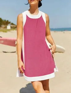 Casual pink and white color-block sleeveless summer dress for women shown at a beach