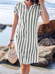 Striped summer shirt dress for women in casual beach setting with woven bag accessory