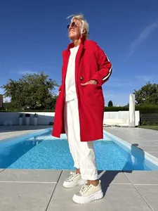 Vista a figura intera di una donna con un cardigan di lana d'agnello rosso in piscina
