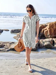 Casual summer vertical striped short sleeve shirt dress for women modeled on a sunny beach