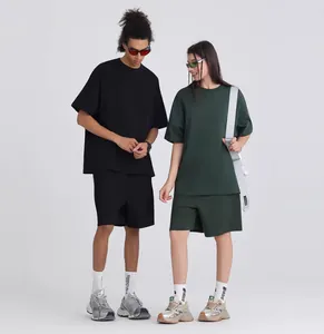 Πλήρης άποψη μοντέλων που φορούν oversized απλά βαμβακερά μπλουζάκια σε μαύρο και σκούρο πράσινο