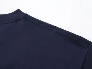 Κοντινό πλάνο διπλής ραφής ώμου σε ένα μπλε σκούρο βαμβακερό μπλουζάκι T-shirt