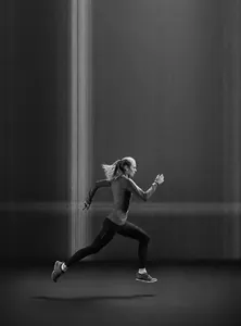 Side view of active woman running in a black long-sleeved quick-dry sports t-shirt