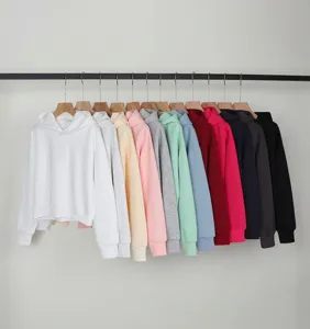Close-up shot of various colorful cropped hoodies hanging on a minimalist garment rack