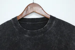 Close-up detail of the round neckline on a heavy washed distressed black cotton T-shirt