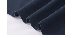 Detailed macro view showing the double-stitched hem and ribbed texture of a navy cotton T-shirt