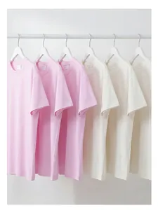 Vue détaillée de t-shirts en coton épais oversize roses et crème sur des cintres.