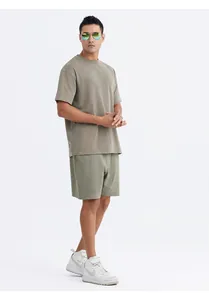Detail view of a men's oversized washed cotton T-shirt and shorts set in khaki green.
