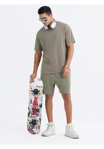 Full body shot of a man wearing an olive green retro washed oversized T-shirt and shorts