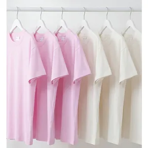 Oversized 280g zwaar katoenen t-shirts hangend in pastelroze en zacht crèmewit