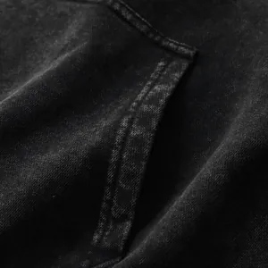 Macro detail of vintage washed black hoodie with 350gsm terry fabric texture.