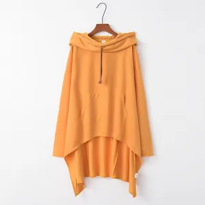 Detailansicht eines übergroßen orangefarbenen Ponchos mit Kapuze und Kängurutasche