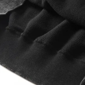 Macro detail of black washed hoodie showing 350g terry fabric and ribbed cuff texture