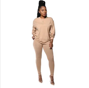 Ganzkörperansicht einer Frau in einem hellbraunen zweiteiligen Loungewear-Set auf weiß.