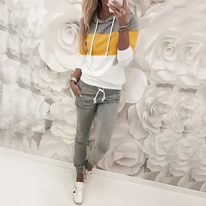 Set casual da donna con felpa color-block e pantaloni grigi, indossato da una modella.