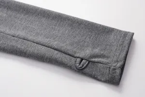 Makroansicht eines grauen Hoodie-Ärmelbundes mit funktionellem Daumenloch-Design.
