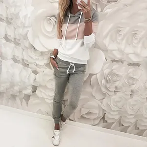 Dettaglio di un set felpa con cappuccio e pantaloni joggers color-block su una modella