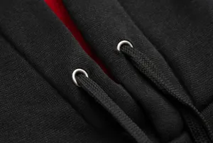 Close-up detail of hoodie drawstring and silver metal eyelets on soft black fabric.