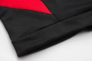 Detailed close-up of black and red knit fabric showing high-quality sewing and texture