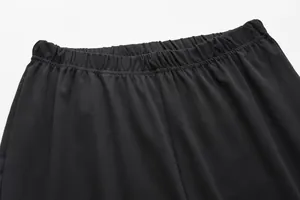 Close-up detail of the comfortable elastic waistband on solid black sports trousers