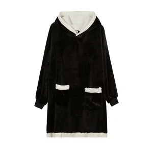 Front view of an oversized black hoodie blanket with white fleece trim and pockets