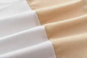 Vista macro della trama del morbido tessuto a maglia bicolore bianco e beige di alta qualità