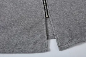 Primer plano detallado de la cremallera de metal y la abertura trasera de una sudadera gris suave