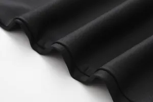 Detailed macro view showing the high-quality black knitted fabric texture and soft drape