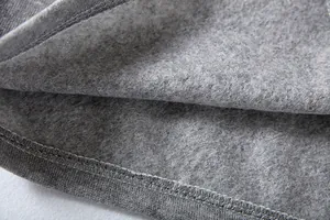 Primer plano del suave forro polar gris y las costuras de un abrigo de mujer.