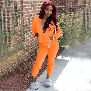Ensemble deux pièces avec sweat à capuche et pantalon de jogging orange pour femme.