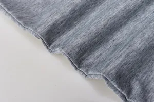 Dettaglio macro della morbida trama in maglia grigio mélange per un set felpa casual da donna