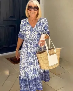 Detailed view of women's bohemian blue and white floral print maxi dress on model