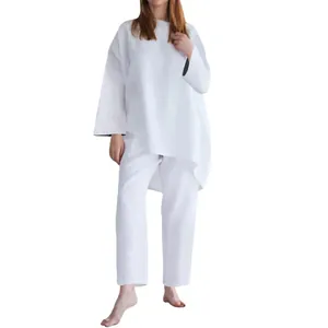 Completo casual da donna in due pezzi bianco con top ampio a maniche lunghe.
