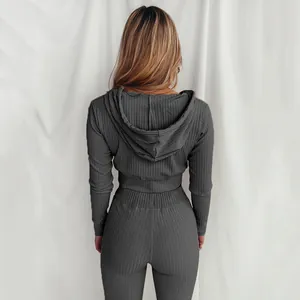 Vista posteriore di un set sportivo a coste da donna con cappuccio e maniche lunghe grigio.