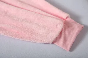 Close-up detail of soft pink fleece fabric and ribbed cuff on warm hoodie blanket