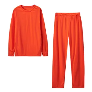 Detailaufnahme des glatten Strickstoffs und des Gummibunds am orangefarbenen Lounge-Set