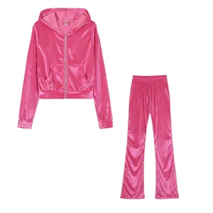 Close-up view of a hot pink velour tracksuit with hooded zip-up and wide-leg pants