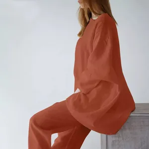 Vista laterale di una donna che indossa un completo casual due pezzi terracotta a maniche lunghe.
