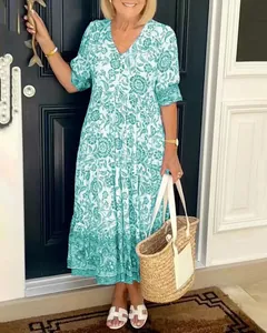Lifestyle shot of a green and white floral tiered midi dress with V-neckline