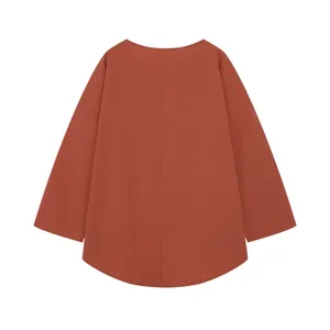 Vista posteriore di una tunica casual oversize a maniche lunghe color terracotta