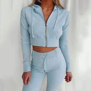 Dettaglio ravvicinato di felpa corta a coste azzurra e pantaloni coordinati da donna